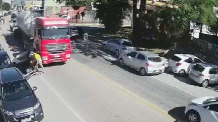 VÍDEO: MOTORISTA ABRE PORTA DE CARRO E JOGA MOTOCICLISTA EMBAIXO DE CAMINHÃO