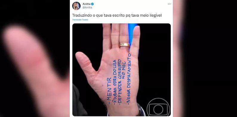 Anitta faz piada com cola vergonhosa de Bolsonaro na mão durante entrevista ao JN